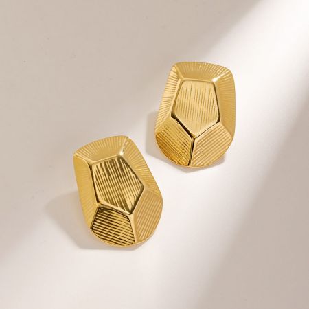 Een paar gouden geometrische pentagon stud oorbellen met een gestreepte textuur.