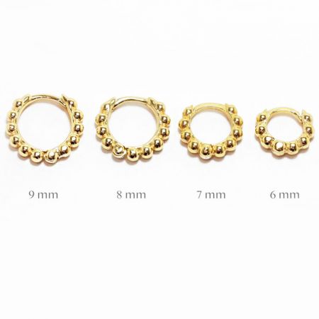 Quattro orecchini a cerchio con perline dorate allineati per mostrare le diverse dimensioni disponibili da 6mm a 9mm.
