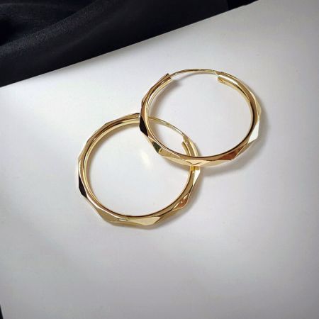 Imagem promocional do elegante brinco de argola dourada de 28mm.