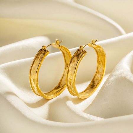Pendientes de aro grandes martillados dorados PVD de acero inoxidable - Un par de pendientes de aro grandes redondos martillados dorados PVD de acero inoxidable sobre un fondo blanco limpio, mostrando su acabado texturizado y diseño clásico.