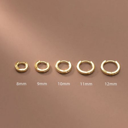 Confronto delle dimensioni degli orecchini a cerchio huggie in zirconia dorata, che vanno da 8mm a 12mm.