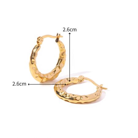 Toma detallada de los pendientes de aro dorados, destacando el diámetro de 2.6 cm.