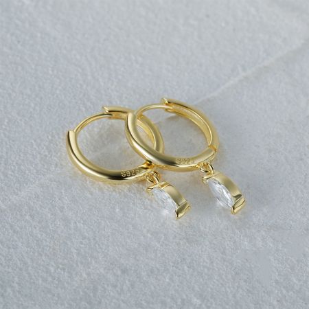 Una foto dettagliata in studio degli orecchini in argento sterling placcato oro con gocce di zirconia cubica trasparente.