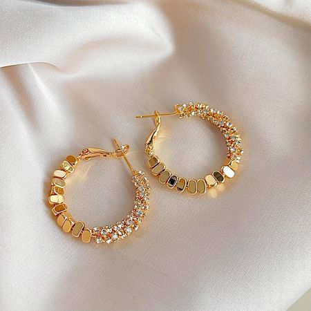 Elegant gold hoop earring adorned with a mix of beautiful stone embellishments.