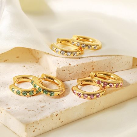 Meerdere paren van de roestvrijstalen creolen die het assortiment beschikbare edelsteen kleuren tonen.