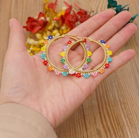 Detailed side view of the colorful beads on the gold hoop earrings.