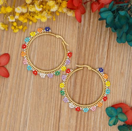 Close-up shot highlighting the intricate floral beadwork of the earrings.