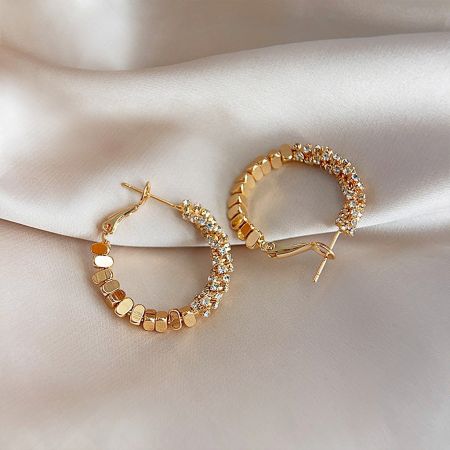 A stylish gold hoop earring with a unique crystal and link design.