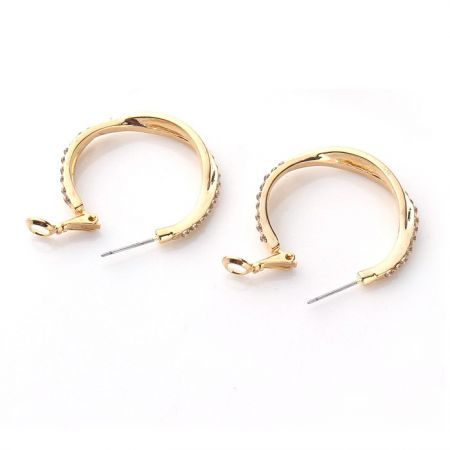 Vue latérale des boucles d'oreilles en or avec strass en cristal, mettant en valeur leur finition polie.