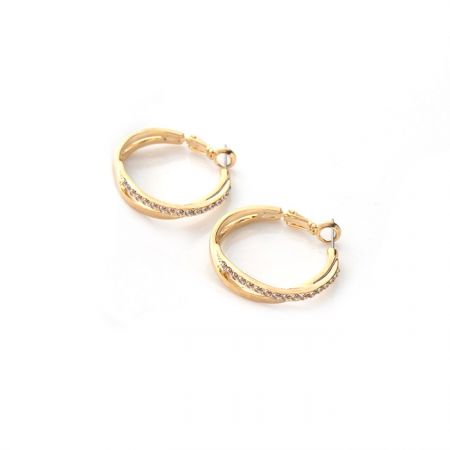Prise de vue détaillée des embellissements en cristal sur les boucles d'oreilles en or.