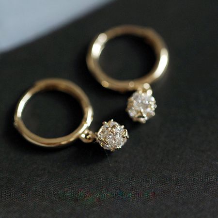 Elegant gold hoop earrings featuring brilliant diamond-like stones.