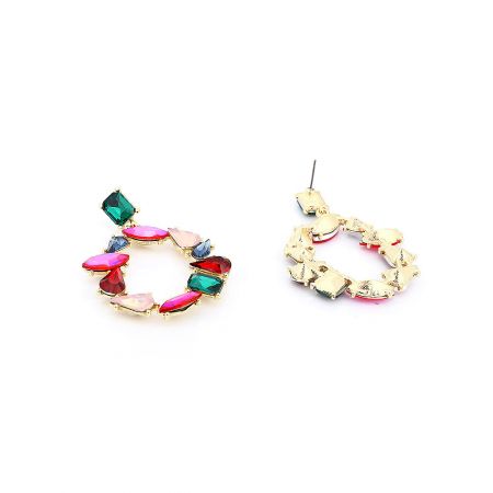 Vue complète des boucles d'oreilles en or ornées de pierres précieuses vibrantes et multicolores, soulignant leur design élégant en goutte.