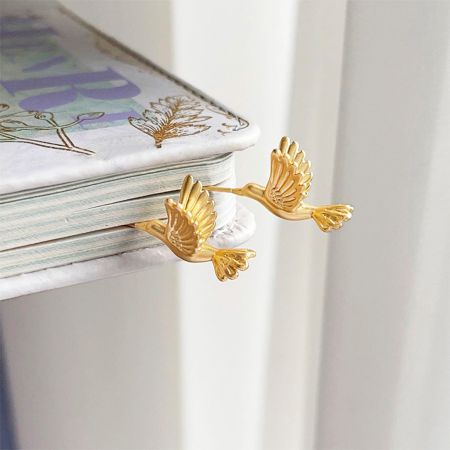 A pair of the 3D bee bird piercing stud earrings on a white background, highlighting the detailed craftsmanship.