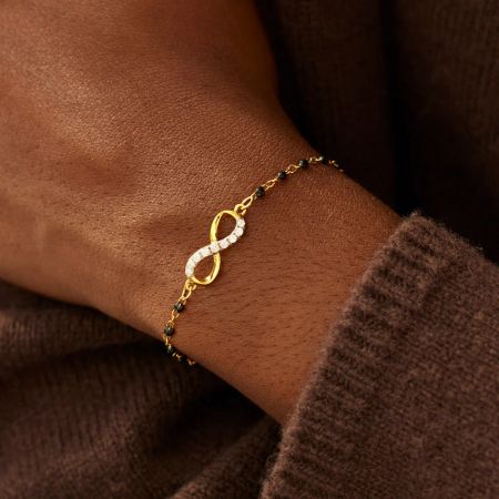 The Infinity of Hope bracelet worn on a wrist, highlighting its elegant design with black beads and a sparkling infinity charm.