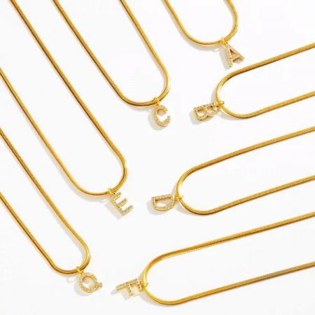 Een collectie van verschillende gouden initialenkettingen, perfect voor personalisatie en layering.