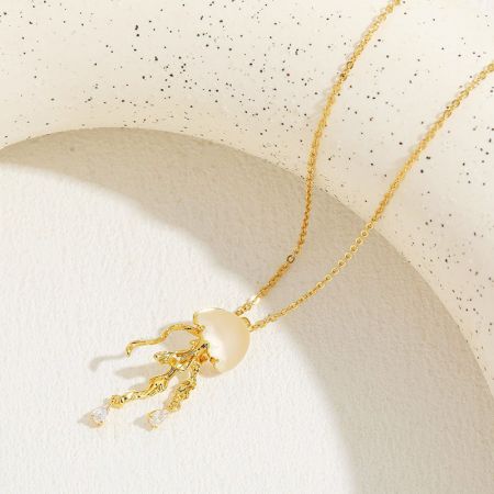 Una variazione del pendente di medusa in oro con un corpo di perla e tentacoli con punte di gemme.