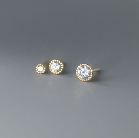 Una presentazione dettagliata del prodotto degli orecchini a bottone Halo in argento sterling 925 placcati in oro con gemme trasparenti scintillanti.