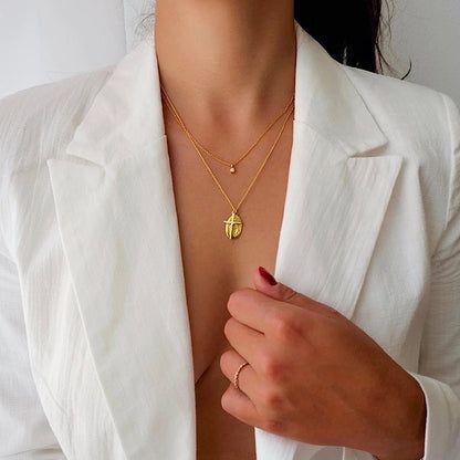 The opal necklace layered with other gold jewelry for a stylish, modern look.
