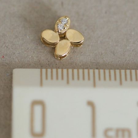 네잎클로버 펜던트의 클로즈업 뷰, 빛나는 큐빅 지르코니아 스톤과 광택이 나는 14K 금 마감이 강조됩니다.