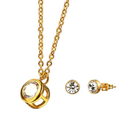 Juego de joyería de solitario redondo claro. - Juego de joyería de solitario redondo claro elegante en dorado, que presenta un collar con colgante de cristal brillante y aretes a juego.