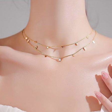 Un look stratificato che presenta più collane con charm geometrici del set in argento sterling.