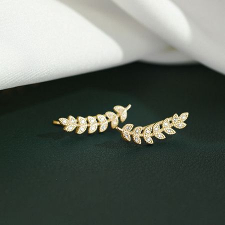 Gouden variant van de oorbellen in de vorm van een tak met een kleine vogel en witte edelstenen.