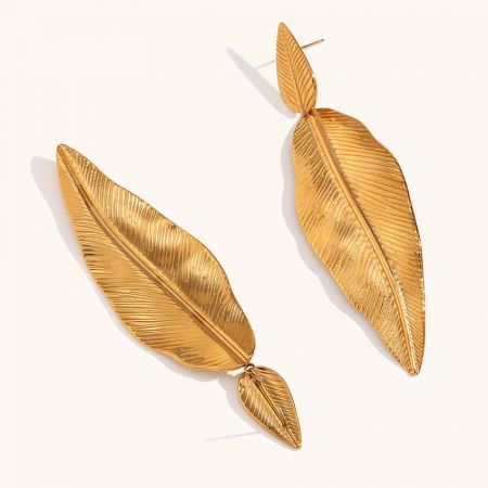 A pair of multi-leaf gold drop earrings against a white background.