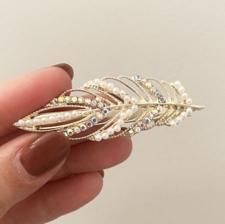 Another angle of the gold-leaf hair accessory, highlighting its delicate structure and the shimmer of the crystals.