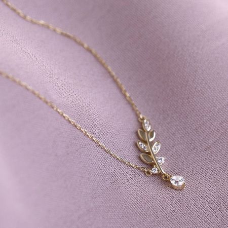 Collar delicado de hoja pequeña de CZ en plata esterlina 925. - Un primer plano del delicado collar de hoja pequeña de CZ en plata esterlina 925 con un acabado dorado radiante, mostrando las piedras de circonio cúbico brillantes en el colgante de hoja.