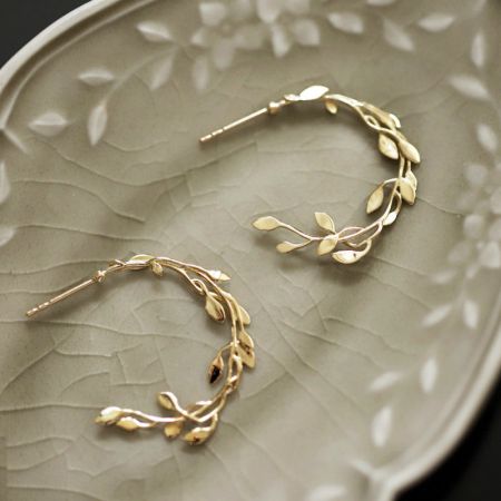 925 Zilver Vergulde Tak & Blad Stud Oorbellen - Een set van 925 sterling zilveren stud oorbellen met ingewikkelde vergulde tak- en bladeren ontwerpen, elegant gepresenteerd.