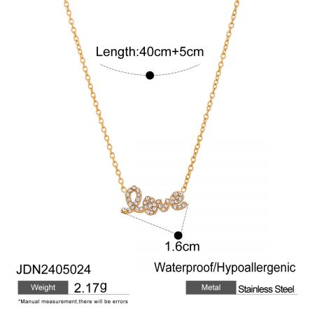 Close-up detail van de cubic zirconia 'liefde' hanger op een gouden roestvrijstalen ketting, die het fijne vakmanschap benadrukt.