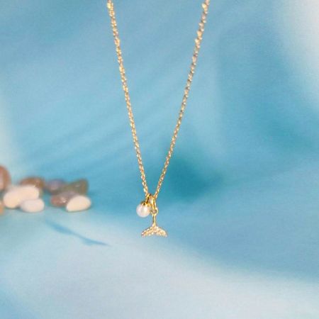 La collana completa a coda di sirena in oro con il suo ciondolo di perla.