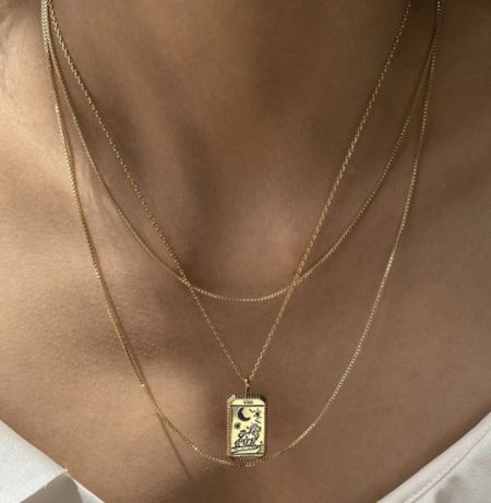 Una vista detallada del collar de péndulo de tarot dorado 'La Luna'.