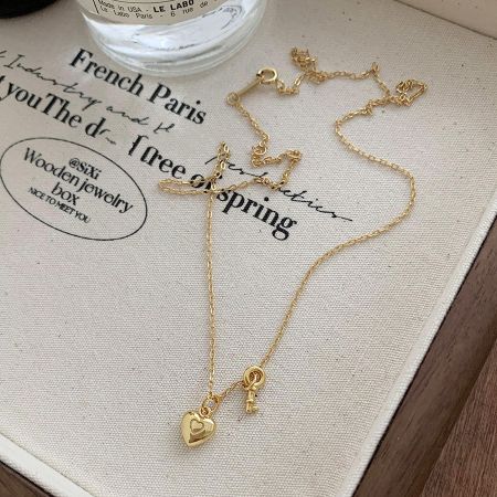 Vue détaillée du pendentif en forme de cœur en or sur un fond en tissu texturé.