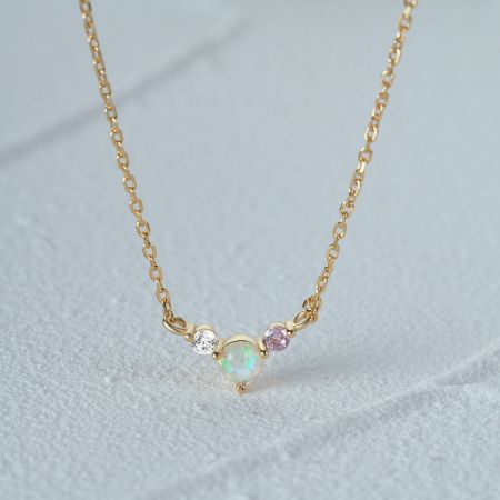 Another design from the necklace set, featuring a gold chain with an opal and gemstone pendant.