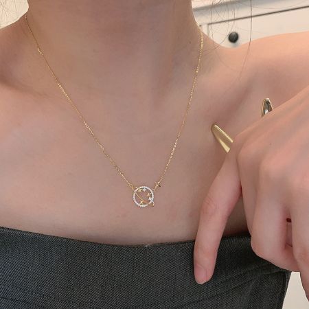 Close-up of the planet pendant with white stone accents resembling a shooting star.