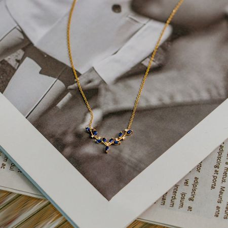 El collar de plata esterlina exhibido sobre un fondo blanco, enfatizando el vibrante colgante azul.