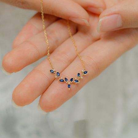 Collar de colgante de planta de hoja de asta de CZ azul de plata esterlina 925. - Vista frontal del collar de plata esterlina 925 con un acabado dorado, exhibiendo el detallado colgante de hoja de asta con brillante circonio cúbico azul.
