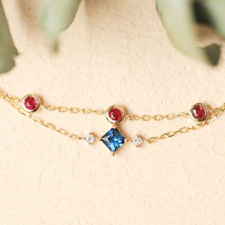 Seitenansicht des zweilagigen Zirkonarmbands, das das goldene Finish und die bunten Steine hervorhebt.