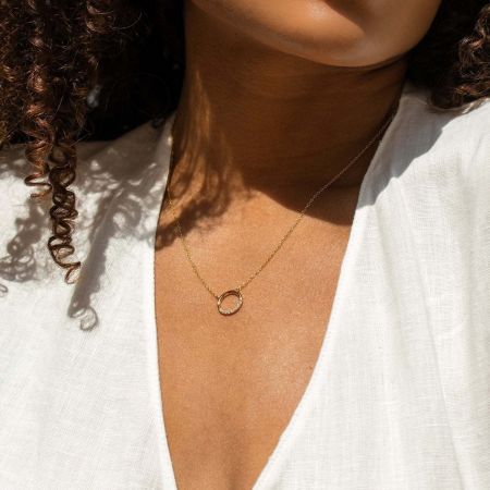 Collar con colgante circular de circonio cúbico de plata esterlina 925 Joyería Simple y Delicada - Un collar con colgante circular de plata esterlina 925 simple y delicado con una piedra de circonio cúbico, mostrado en un acabado tono dorado, exhibido en una bandeja de joyería minimalista.