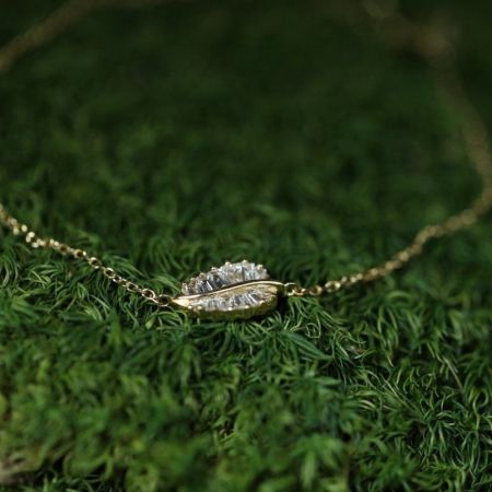 Detailed view of the square cubic zirconia stones on the 14K gold-plated leaf bracelet.