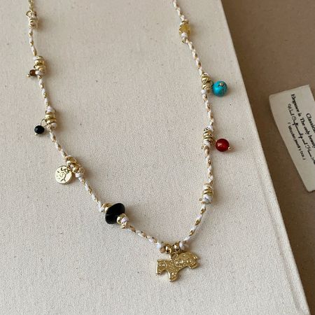 Detailed view of the natural stone beads and vintage-style horse pendant.