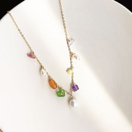 Another angle of the gold necklace with colorful stones and pearls, emphasizing its craftsmanship.