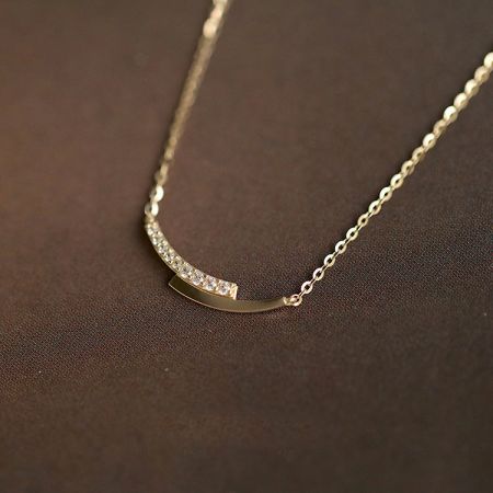 Collar con colgante de intersección de cristal pavé de plata 925. - Un primer plano de un collar de plata esterlina 925 del conjunto de cristal pavé, con un acabado dorado y un colgante curvado distintivo con cristales brillantes.