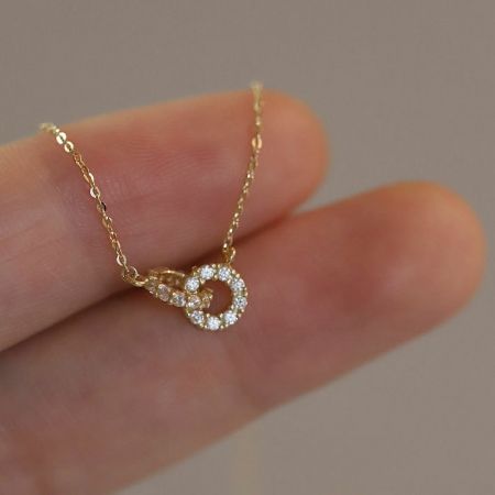 Collar de doble círculo de plata esterlina 925 chapado en oro, joyería para damas de honor - Un primer plano del collar de doble círculo de plata esterlina 925 chapado en oro, mostrando los anillos entrelazados con acentos de circonita cúbica.