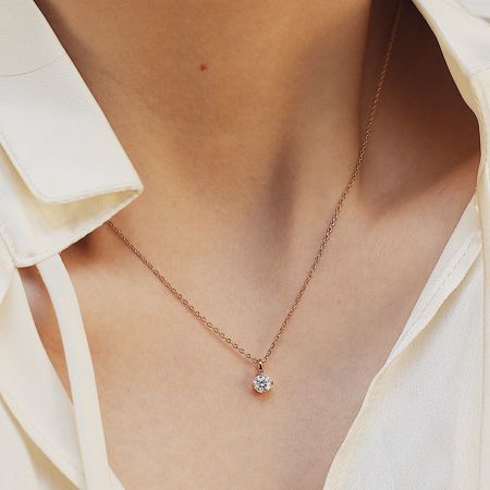 Detailed view of the solitaire stone pendant on the gold-finished necklace.