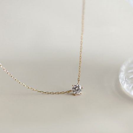 Collar de colgante de piedra solitaria redonda con engaste de garra de plata 925 - Un primer plano de un collar de colgante de piedra solitaria de plata esterlina 925 con un acabado dorado, exhibido sobre un fondo blanco limpio.