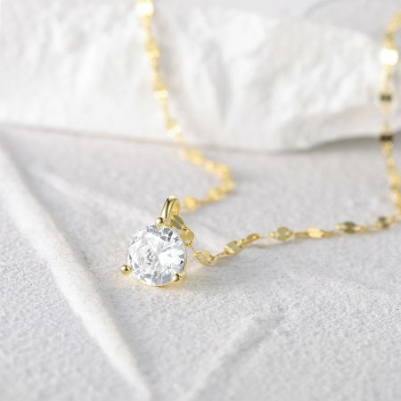 Close-up of the gold-finish single stone necklace pendant.