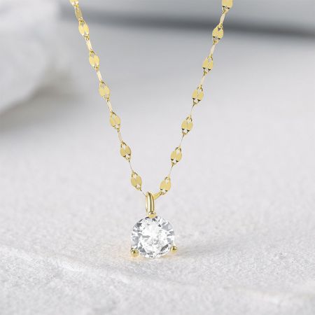 Detailed view of the 3-prong setting on the gold necklace.
