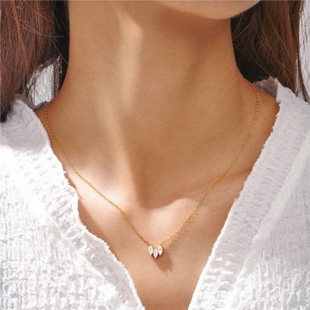 Detailed view of the double marquise-cut zircon pendant on the gold necklace.